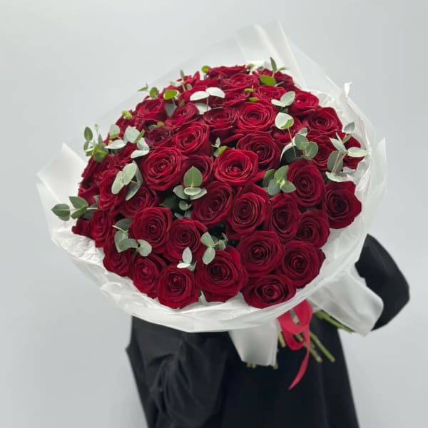 Large bouquet of red roses wrapped in white paper
