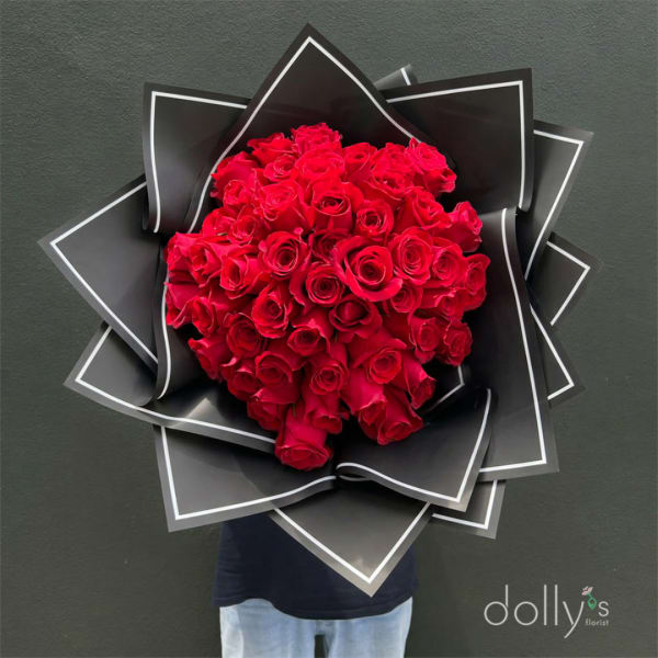 Large bouquet of red roses wrapped in black paper