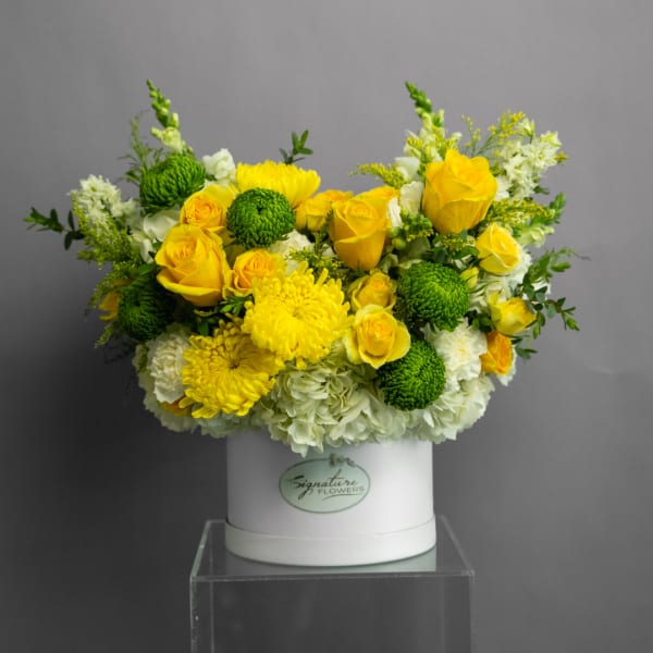 Yellow roses and green chrysanthemums in a white hat box