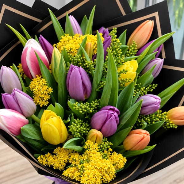 Bouquet of multicolored tulips wrapped in black paper