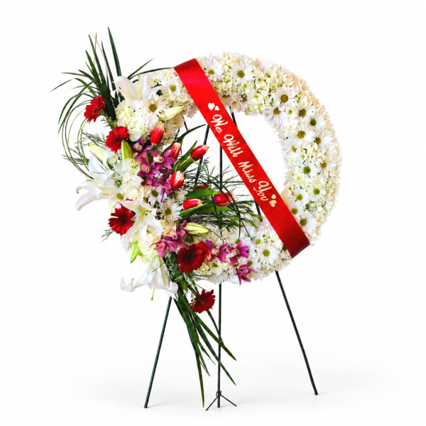 Floral standing wreath with white daisies and red flowers on an easel