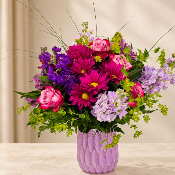 Pink and purple mixed bouquet in a lavender vase