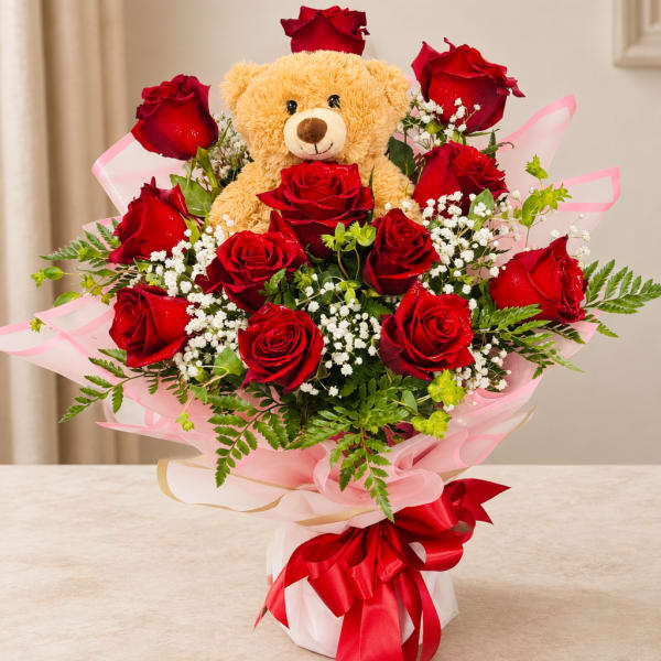 Red rose bouquet with a teddy bear centerpiece and pink wrapping