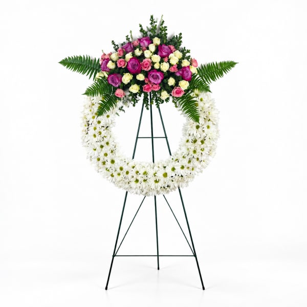 Standing floral wreath with white daisies and pink roses on an easel