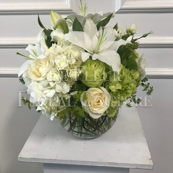 White floral arrangement in a round glass vase