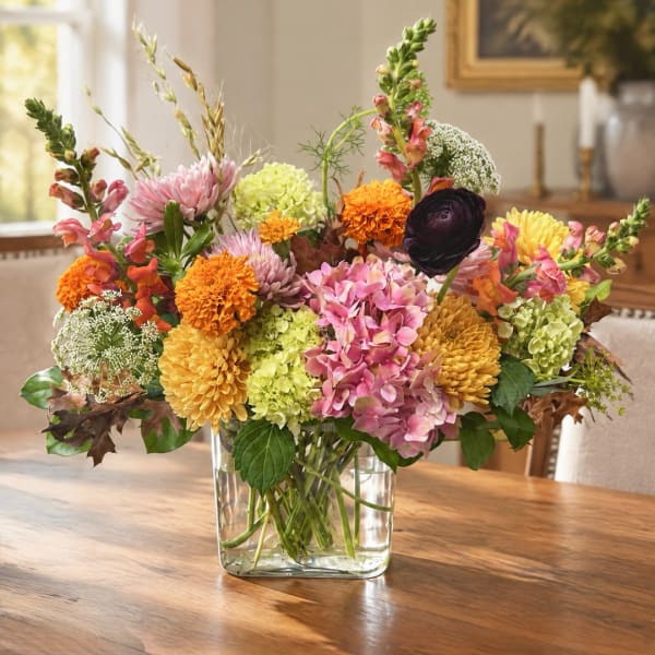 Mixed bouquet of colorful flowers in a clear glass vase