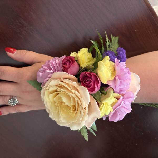 Hand corsage with pink, yellow, and cream flowers