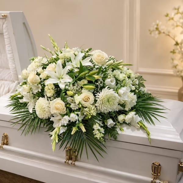 White floral spray on a white casket