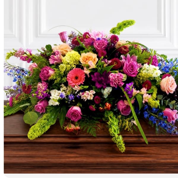 Large mixed flower arrangement in bright pink, peach, purple, and blue