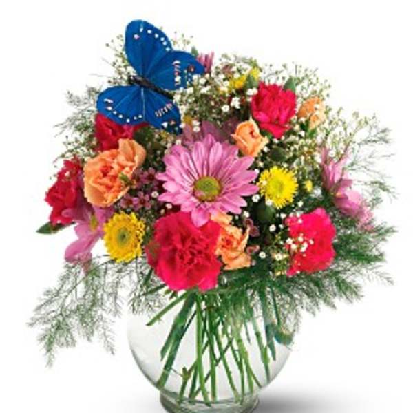Colorful mixed bouquet in a clear glass vase with a blue butterfly decoration