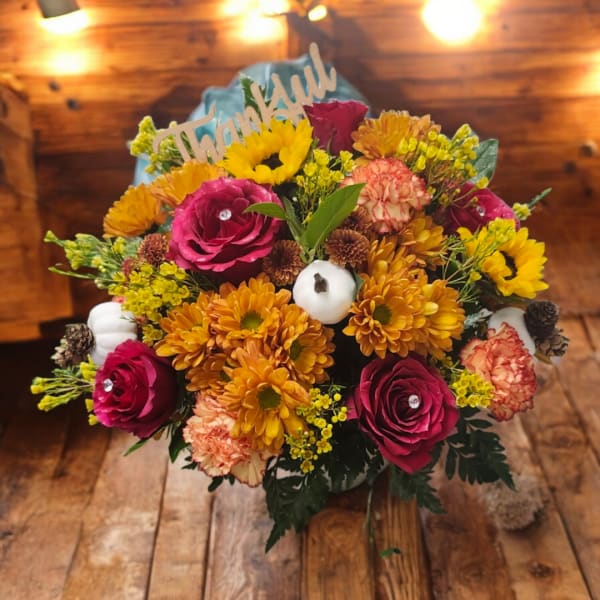 Mixed bouquet with roses, chrysanthemums, and a "Thankful" sign