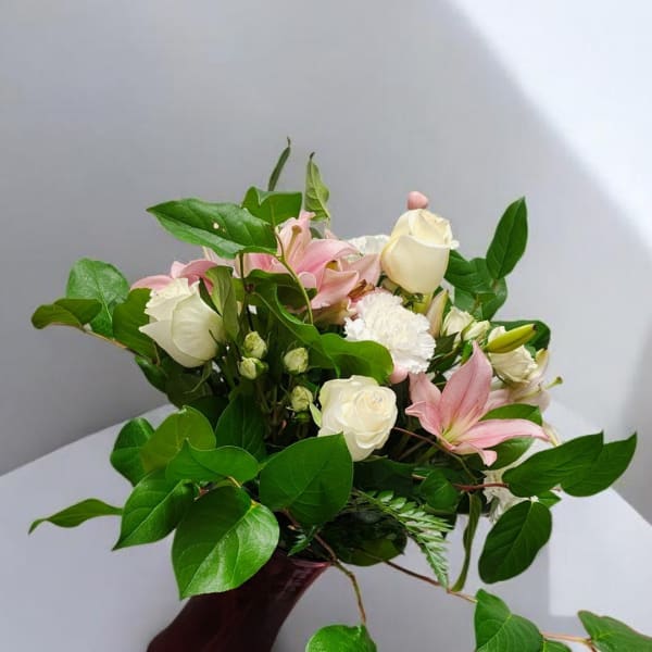 Pink lilies and white roses in a hand-tied bouquet