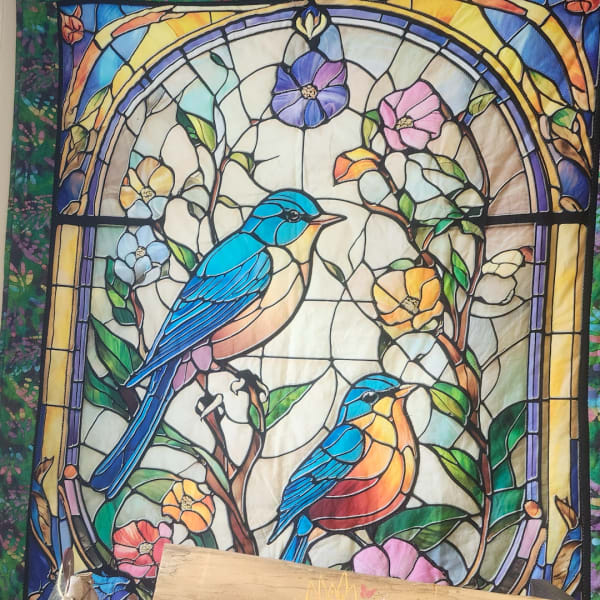 Stained glass panel with two blue birds among colorful flowers
