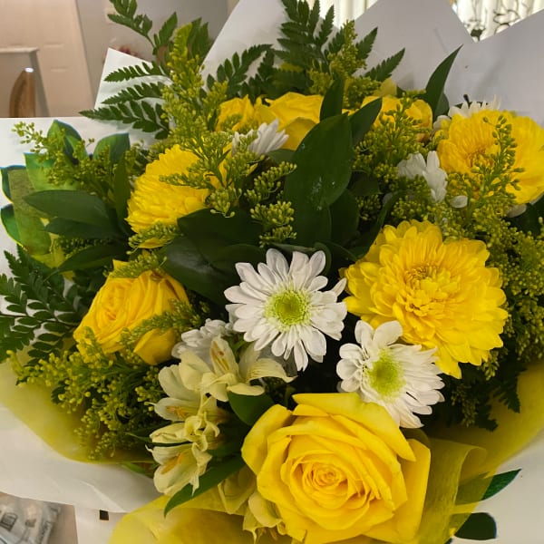 Yellow roses and white daisies in a wrapped bouquet