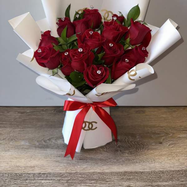 Bouquet of red roses wrapped in white paper with a red ribbon