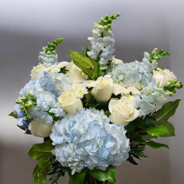 Blue hydrangeas and white roses arranged in a bouquet