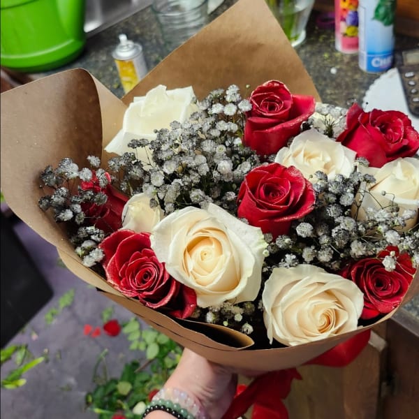 Bouquet of red and white roses wrapped in brown paper