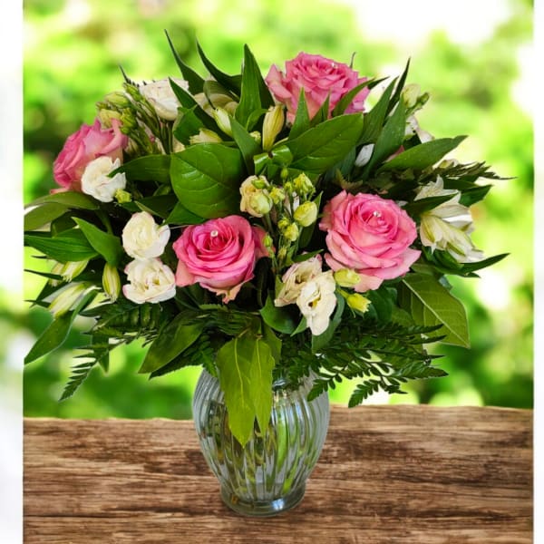 Pink and white rose bouquet in a clear glass vase