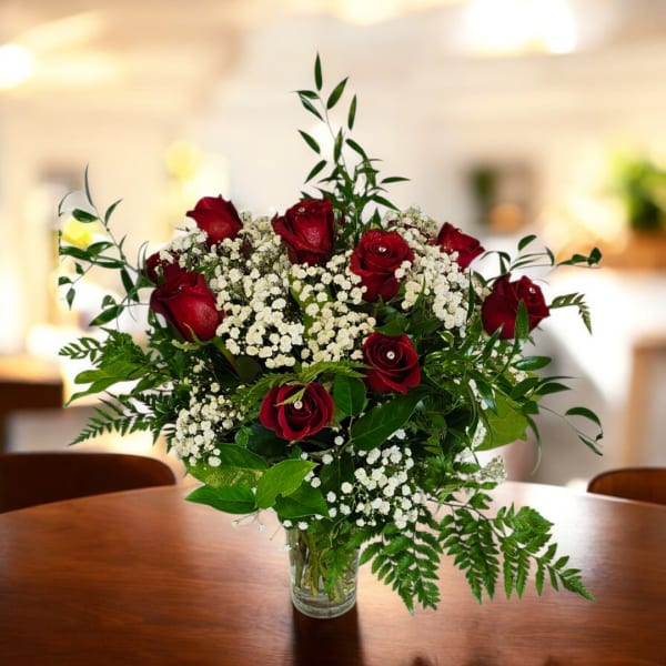 Red roses and white baby's breath in a clear glass vase