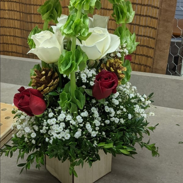 White and red roses arranged with baby's breath in a wooden box