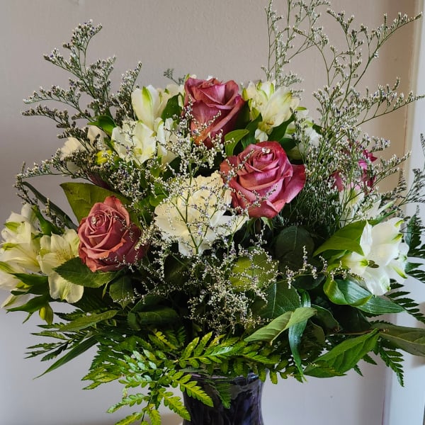 Bouquet of pink roses and white lilies in a glass vase