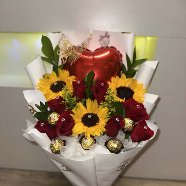 Bouquet of red roses and sunflowers with a heart balloon and chocolates