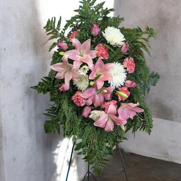 Pink lilies and white chrysanthemums in a standing floral spray