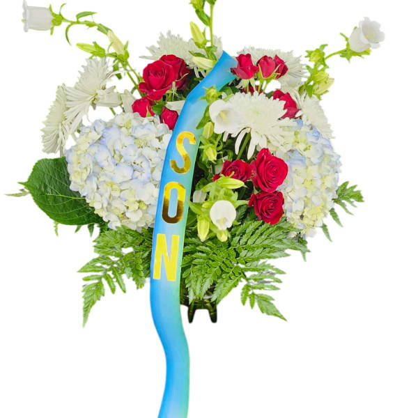 Standing floral spray with red roses, white blooms, and a blue ribbon