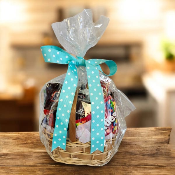 Gift basket wrapped in clear cellophane with a blue polka-dot ribbon