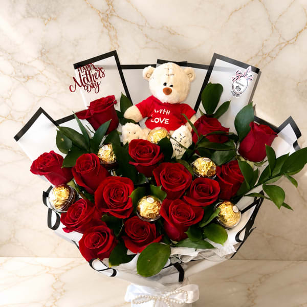 Glass vase with white paper, teddy bear, Ferrero Rocher chocolates, ribbon bow and pearl