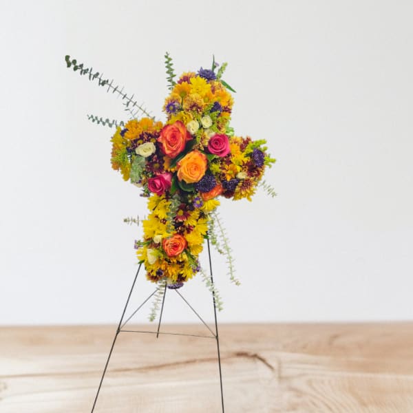 Colorful floral cross on a metal stand