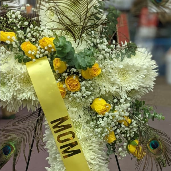 White chrysanthemum and yellow rose funeral spray with a yellow ribbon