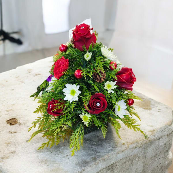 Small holiday floral arrangement with red roses and white daisies