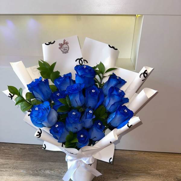 Bouquet of blue roses wrapped in white paper with a ribbon
