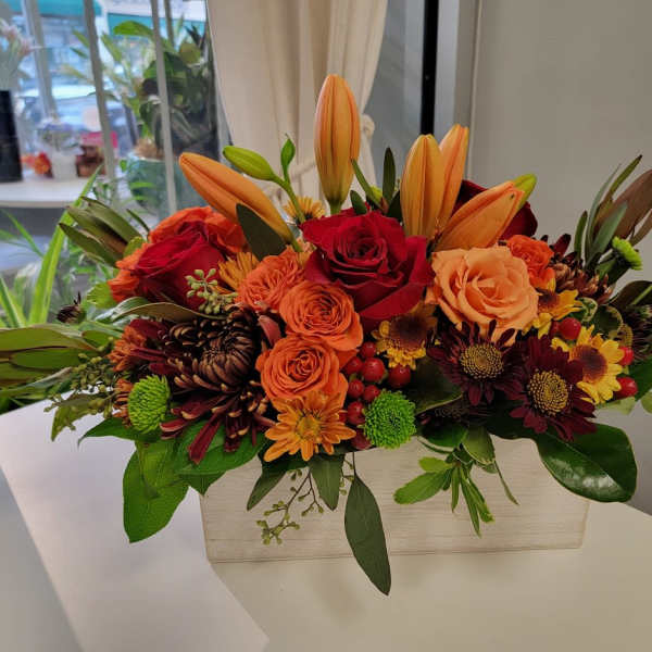 Orange lilies and red roses in a rectangular vase