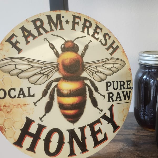 Round honey sign with a bee graphic beside a mason jar of honey