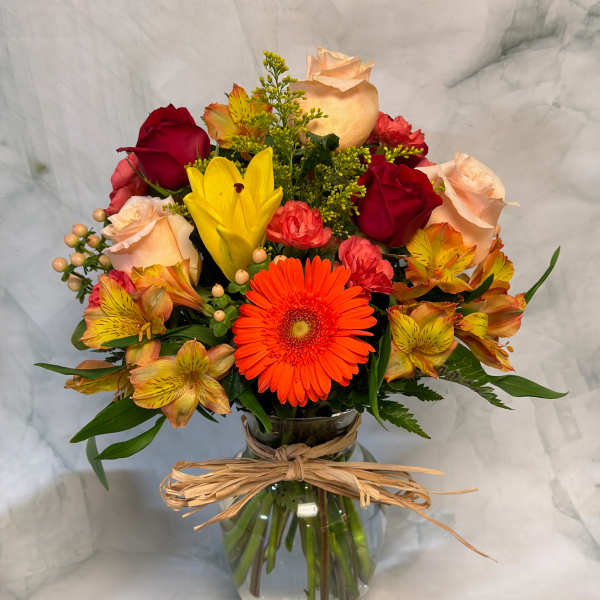 Mixed bouquet of roses, gerbera daisies, and alstroemeria in a glass vase