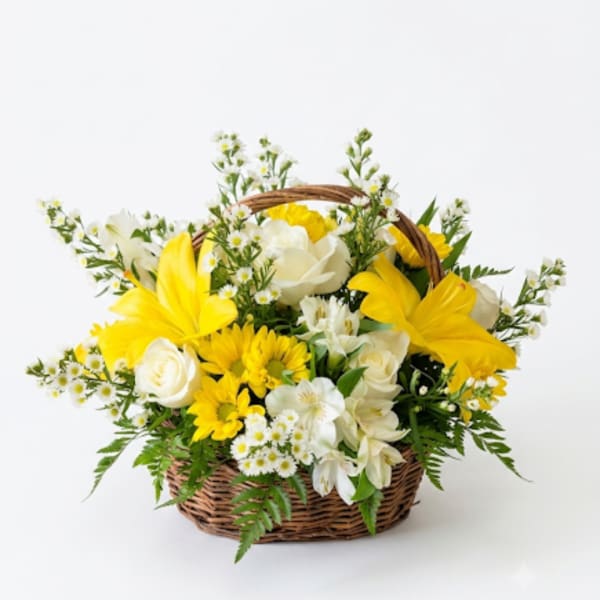 Yellow and white flowers arranged in a wicker basket