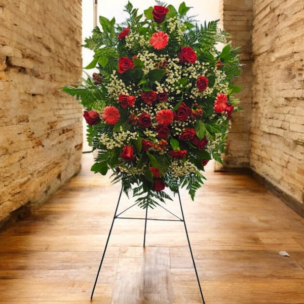 Large red floral standing spray on a metal easel