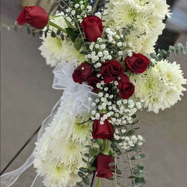 Red roses and white chrysanthemums arranged with baby's breath and ribbon