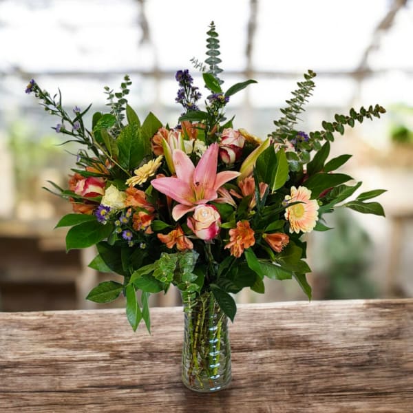 Mixed bouquet with pink lilies and roses in a clear glass vase