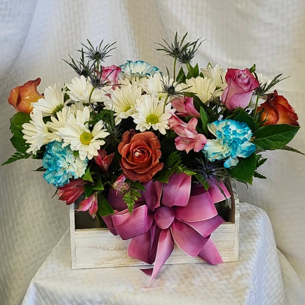 Mixed bouquet of roses, daisies, carnations, and alstroemeria in a wooden box