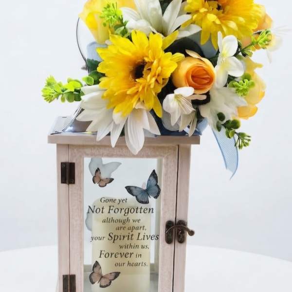 Yellow and white floral arrangement on a memorial lantern