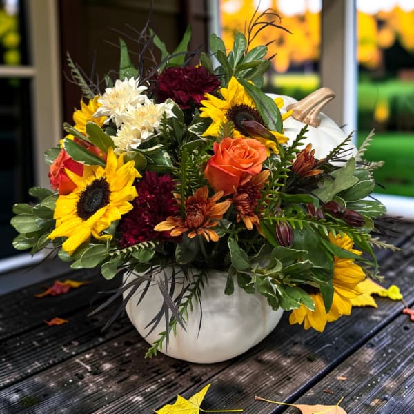 Bouquet of sunflowers, roses, and mums in a white pumpkin vase