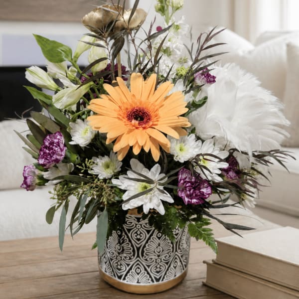 Mixed bouquet in a patterned black-and-white vase with an orange gerbera daisy