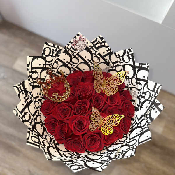 Bouquet of red roses wrapped in black-and-white patterned paper with butterfly accents