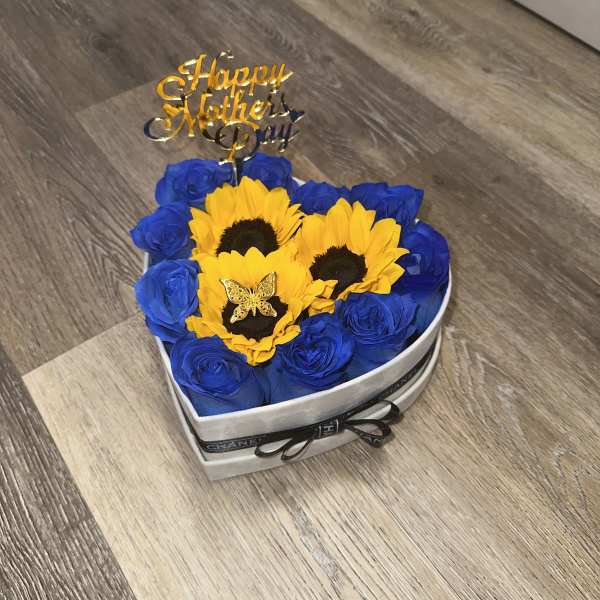 Small box with red roses and sunflowers, a gold metal butterfly, ribbon with Prada logo