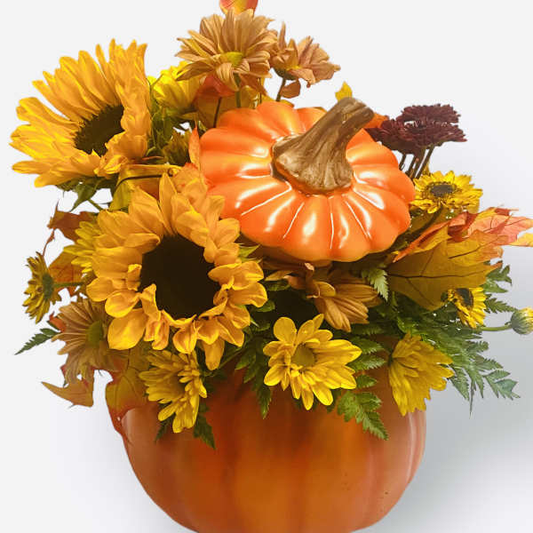 Pumpkin-shaped floral arrangement with sunflowers and autumn mums in an orange container
