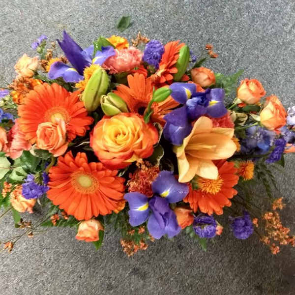 Colorful mixed bouquet with orange gerberas, roses, and purple irises