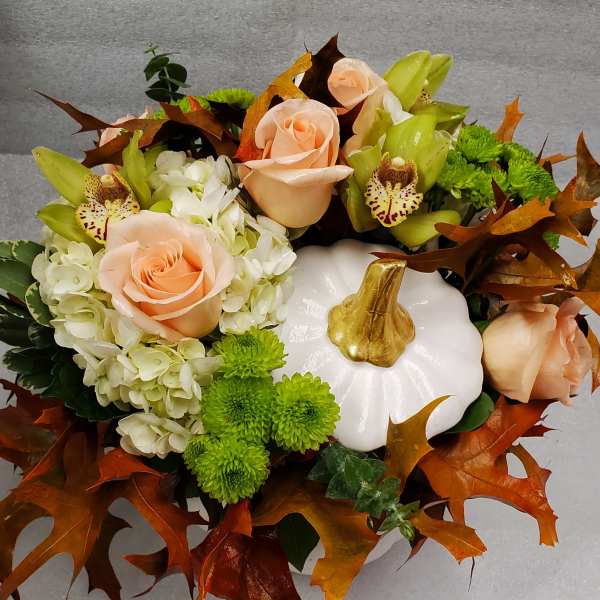 Pumpkin-shaped floral arrangement with peach roses and green orchids